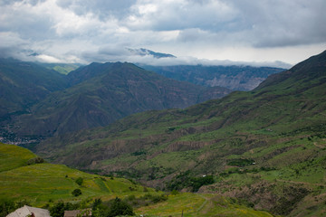 Mountain landscape beautiful green mountains with Alpine lush meadows cloudy sky background