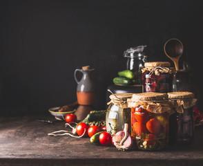 Vegetables and fruits canning. Various preserve glass jars on dark table. Homemade harvest storage....