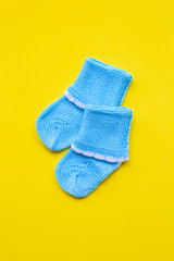 Baby socks on yellow background.