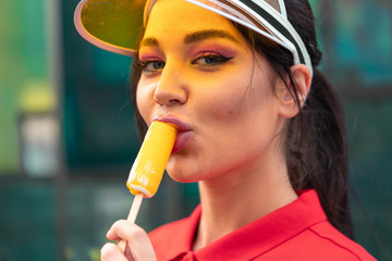 Young sexy brunette woman eating ice cream at sunny hot day. seductive provocative woman