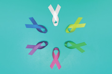 World cancer day background. Colorful ribbons, cancer awareness. blue surface from above. CMYK...