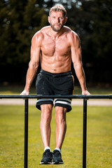 calisthenics hand stand fitness, sport, training and lifestyle concept - young man exercising on parallel bars outdoors