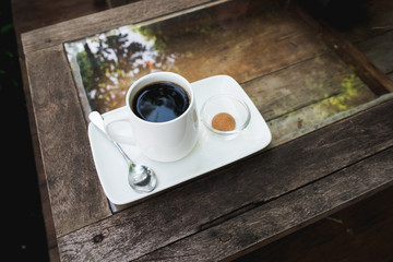 top view black coffee in the white cup on wooden table.