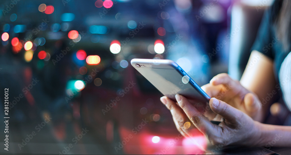 Wall mural woman using mobile smart phone in the night light colorful background