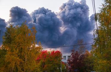 Puffs of smoke from the burning construction market over the residential area of Moscow