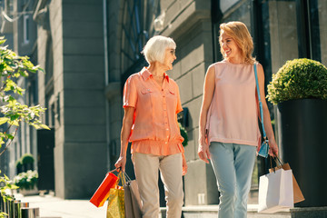 Delighted ladies smiling after going shopping