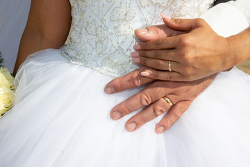 Rings for wedding bride and groom hands in white marriage dress background