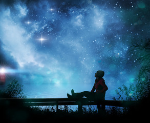 Naklejka na ściany i meble Girl watching the stars in night sky