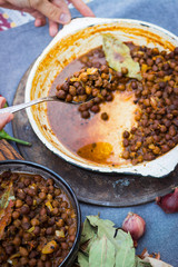 Black chickpeas. Kala chana masala with gravy. Woman hands holds, take spicy Indian traditional food.