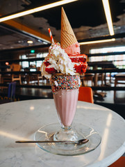 Pink freak shake with ice cream, cake and whipped cream