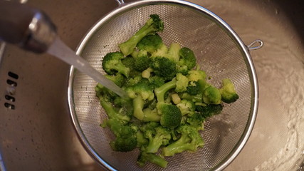 Green cabbage broccoli. Fresh healthy food. Vegetarian food. Metal sieve for washing vegetables.