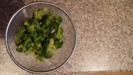 Green cabbage broccoli. Fresh healthy food. Vegetarian food. Metal sieve for washing vegetables.