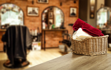 Table background with towels and blurred hairdresser and barber shop view.