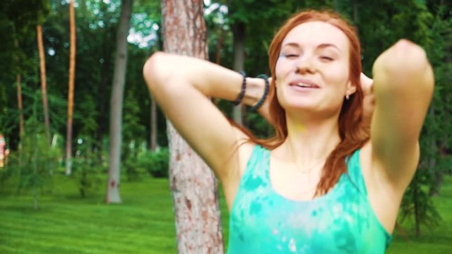 happy red haired girl with wet hair and clothes celebrates Holi colors holiday