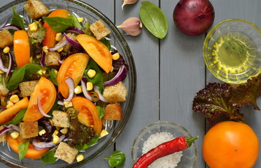 Salad with yellow tomatoes, sweet corn, basil and croutons, panzanella, view from above, copy space