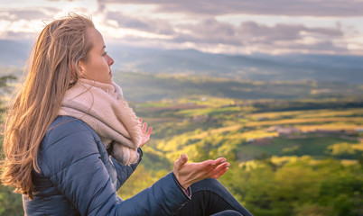 Christian worship and praise. A young woman is praying and worshiping in the evening.