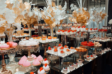 Candy bar.  Table with deserts, strawberry cupcakes.  Sweet table for banquets, weddings, parties. Cupcakes, tarts, pies and cakes on background. 