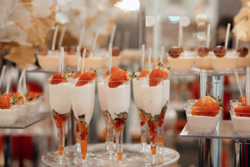 Table with sweets, buffet with cupcakes, candies. Sweets with strawberries. Delicious wedding reception candy bar dessert table. Candy bar. 