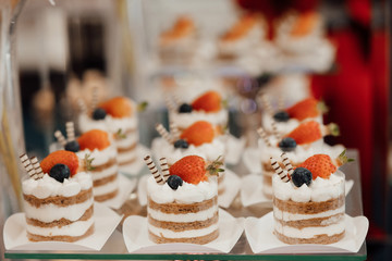 Buffet with sweets. Cakes with strawberries and blueberry. Sweet table for banquets, weddings, parties. Candy bar.The holiday table decoration.