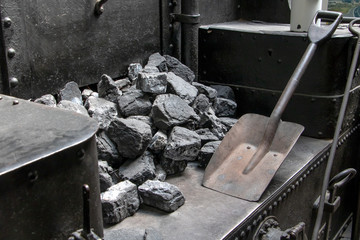 Interior of old vintage steam locomotive cabin. A coal with shovel in a coal tender in steam...