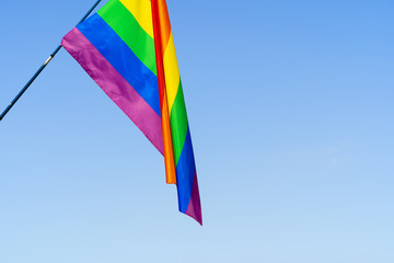 LGBT waving flag in the sky on flagpole