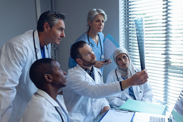 Medical team looking at x-ray at desk in hospital