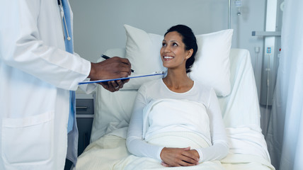 Obraz premium Male doctor interacting with female patient in the ward