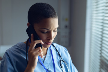 Female doctor talking on mobile phone in hospital - Powered by Adobe