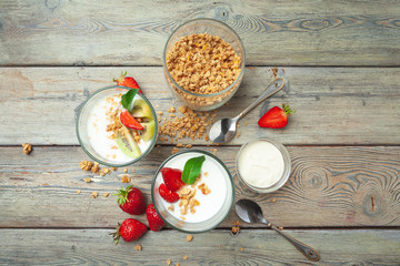 Healthy breakfast with yogurt, berries and granola on wooden table top view