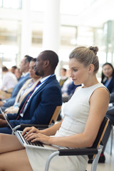 Young Caucasian female executive using laptop in conference room