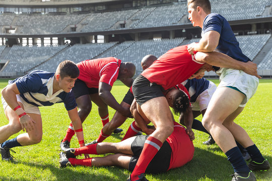 Male rugby players playing rugby match in stadium