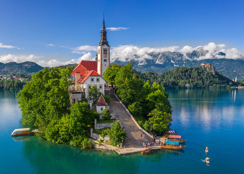Bled, Slovenia - Aerial drone view of beautiful Lake Bled (Blejsko Jezero) with the Pilgrimage Church of the Assumption of Maria and Bled Castle and Julian Alps at backgroud on a bright summer day