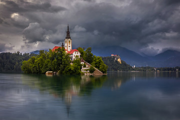 Bled, Slovenia - Beautiful cloudy morning at Lake Bled (Blejsko Jezero) with the Pilgrimage Church of the Assumption of Maria and Bled Castle and Julian Alps at background at summer time