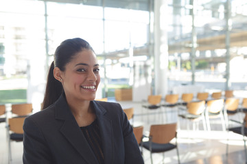 Smiling businesswoman standing in conference room 
