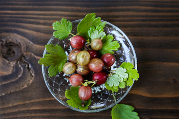 sweet fresh gooseberry berry in a bowl on dark background.