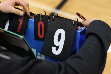 Scorekeeper keep attention during volleyball match not to forget turns numbers. White number nine on black background. Sport abacus. Indoor sport. Summer brigade