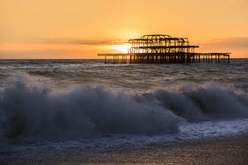 Landscape of old pier at sunset with waves La Manche Brighton, Sussex, South of England
