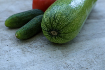 Fresh zucchini with cucumber on wooden table close up