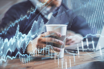 Forex graph with businessman working on computer in office on background. Concept of hardworking....