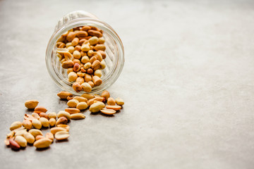 Roasted peanuts in a glass on a gray background. Healthy lifestyle and fast snack concept. Copy space for text. Horizontal
