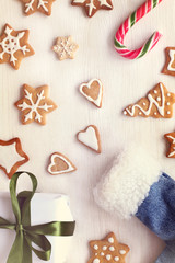 Christmas cookies, gift, candy staff and boots top view. winter holiday background