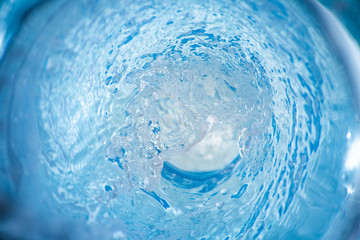 Background with a stream of blue clear liquid