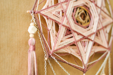 Closeup modern mandala with quartz crystals, amethyst, moonstone, tassels and chain on craft paper...