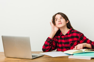 Young teenager going back to her routine doing homeworks trying to listening a gossip.