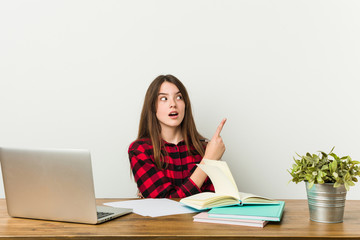 Young teenager going back to her routine doing homeworks pointing to the side