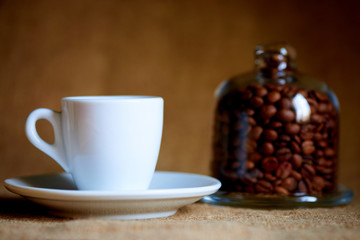 White cup with coffee on a blurred background.