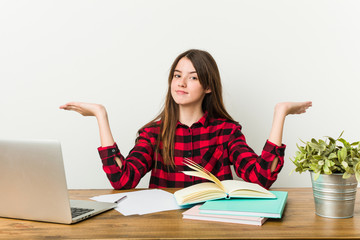 Young teenager going back to her routine doing homeworks makes scale with arms, feels happy and confident.
