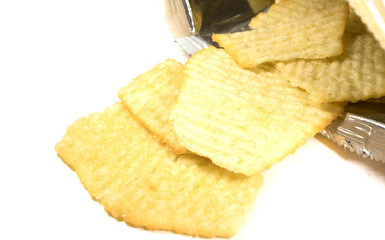 potato chips poured from a package on white background