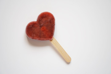 heart shaped homemade berry fruit smoothie popsicle or ice lolly or ice pop on white background