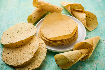 Gujarati papad or papadum in raw dried form with roasted cone, roll and flat variation